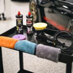 Sprays and Cloths on Table near Sports Cars